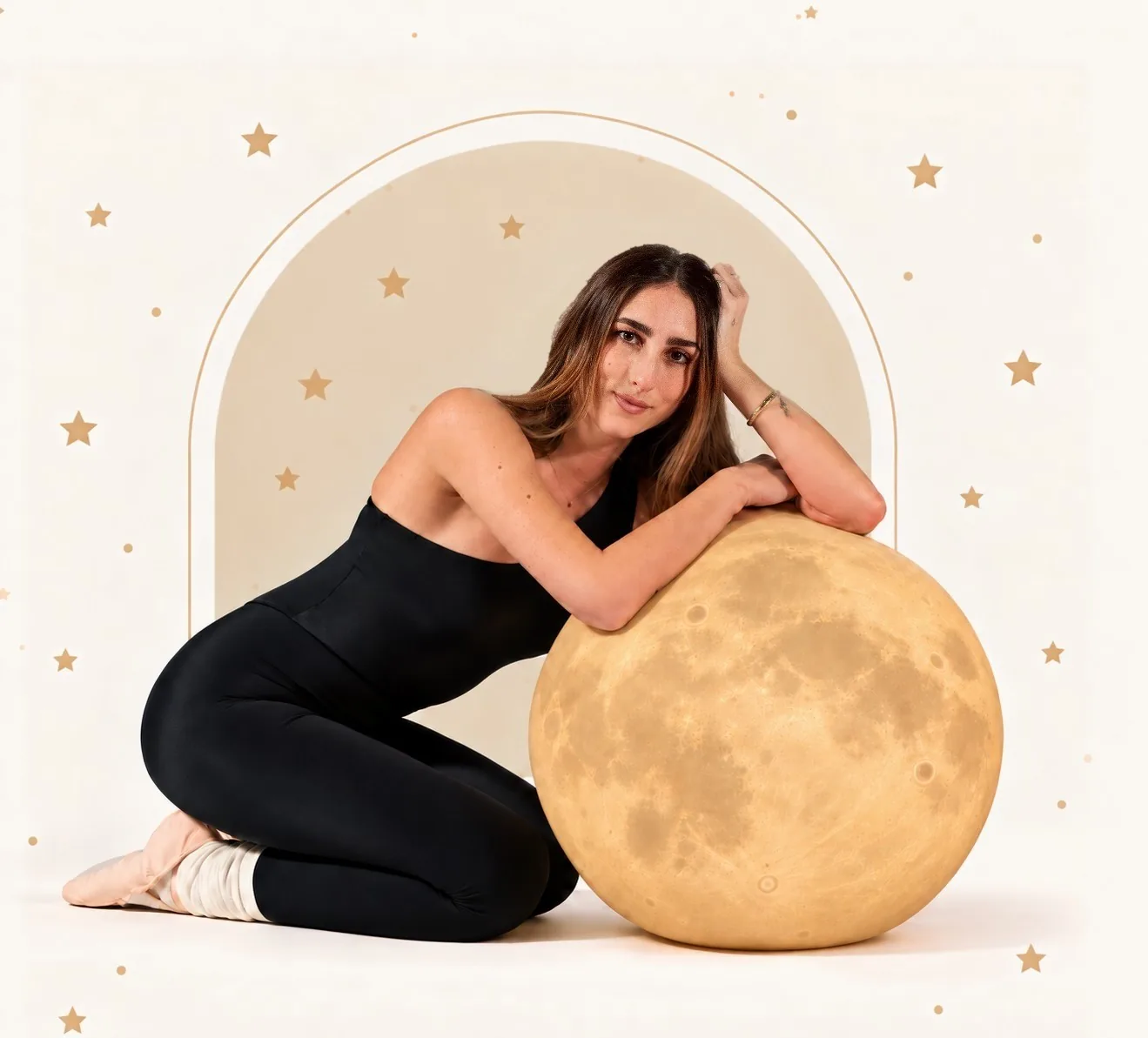 Francesca Parrini seduta a terra, appoggiata a una grande luna, davanti a un arco con stelline